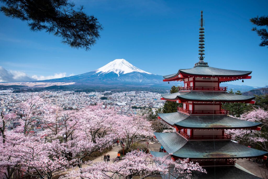 Vista panorámica del Monte Fuji al amanecer, rodeado de naturaleza y reflejado en el lago Kawaguchi, un destino emblemático para viajes a Japón