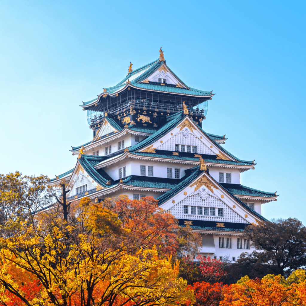Templo en Osaka rodeado de árboles con tonos naranjas, una escena típica de los viajes a Japón