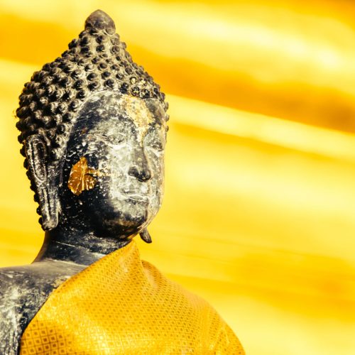 Estatua de Buda con tonos dorados en Tailandia, símbolo de paz y espiritualidad