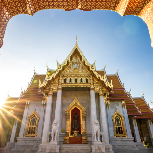 Templo tailandés en Bangkok iluminado por los colores cálidos de un atardecer