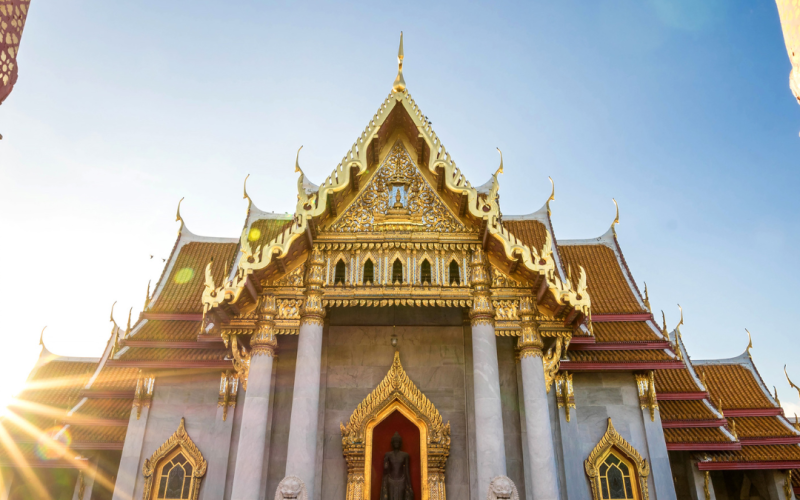 Templo tailandés en Bangkok iluminado por los colores cálidos de un atardecer