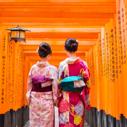 Dos japonesas con traje tradicional en Fushimi Inari-taisha, un destino icónico en los viajes a Japón